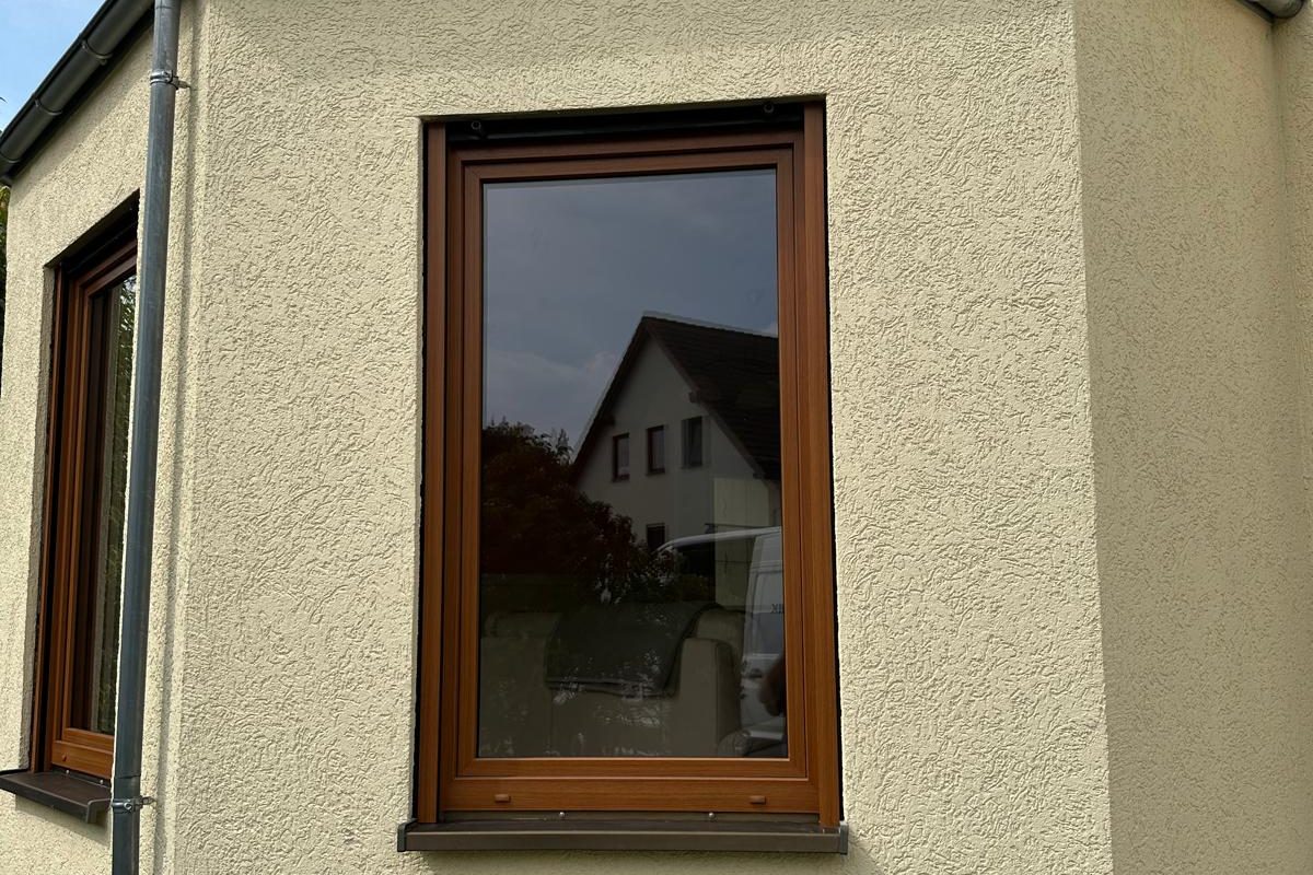 Fenster in Holzdekor in einem verputzten Erker