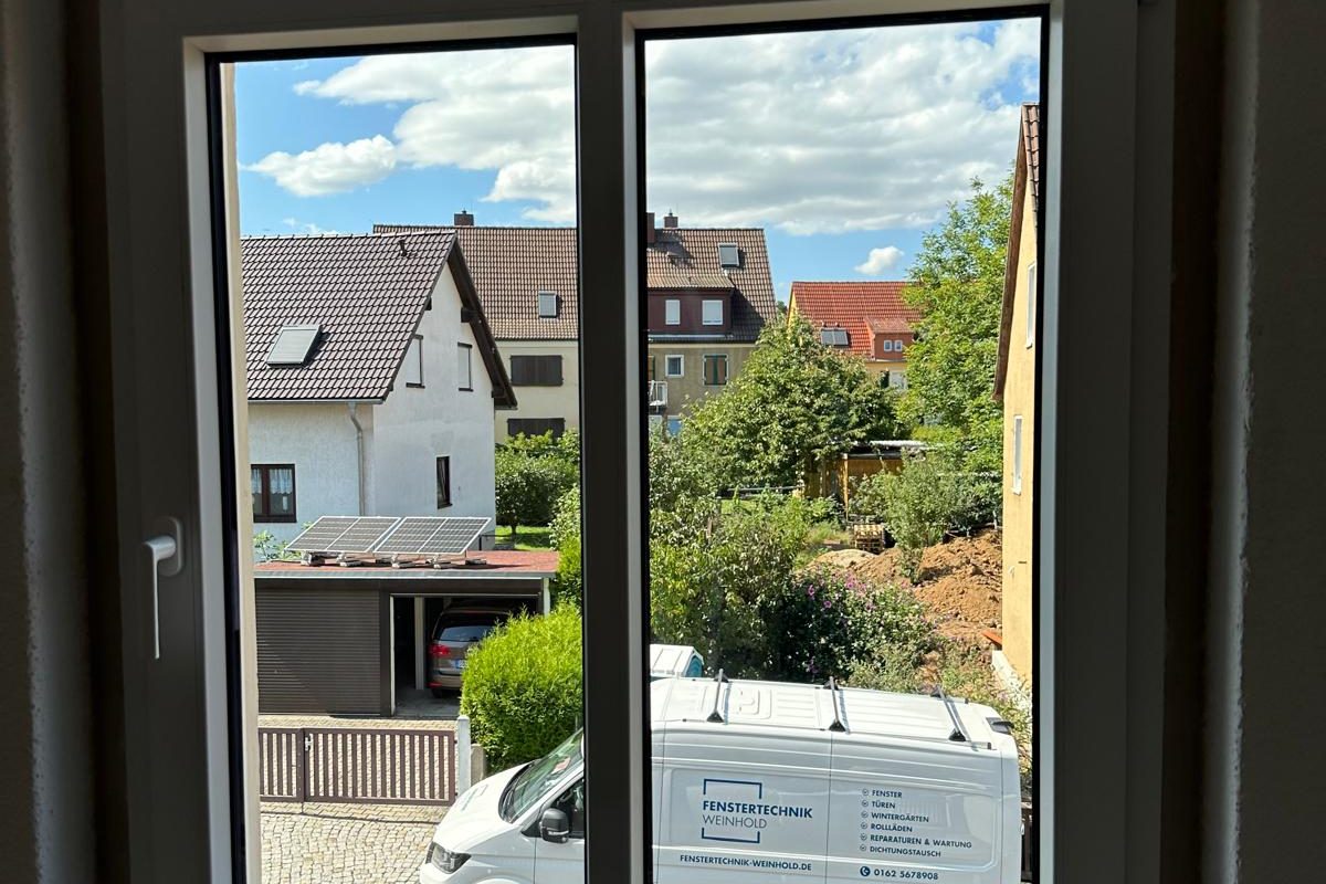 Zweiflügliges weißes Fenster von innen mit Blick auf die Straße